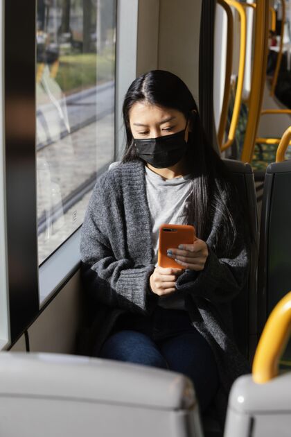 女性公共汽车上戴着面具的年轻女子姿势科技户外
