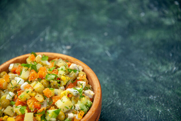 里面前视图蔬菜沙拉从煮熟的蔬菜混合在黑暗背景的圆形盘子里午餐圆形蔬菜沙拉