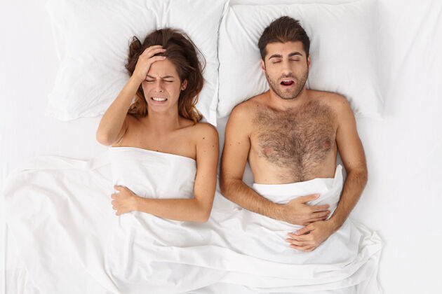 噪音特写这对躺在床上白毯子下的夫妇男性夜晚醒来