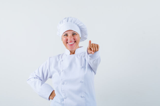 模特一位身穿白色制服的女厨师向前指了指 看上去很快乐女人时尚欢乐