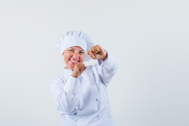 时尚一位身穿白色制服的女厨师摆出获胜者的姿势 看上去很快乐时尚人物快乐