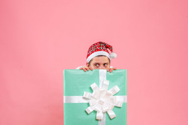 年轻男性正面图：穿着白色衬衫的年轻男性 粉色背景的礼物情感风景圣诞节