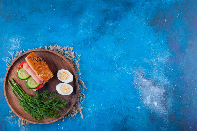 切片三明治 莳萝和鸡蛋片放在蓝色的船上开胃菜风味美味