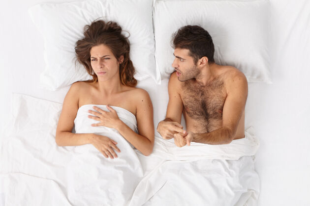 压力特写这对躺在床上白毯子下的夫妇男朋友冲突伙伴关系