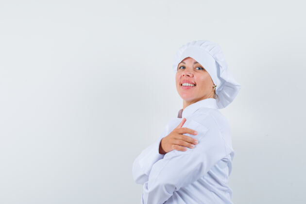 休闲身穿白色制服的女厨师双手交叉站着 看上去很自信欢呼交叉女人