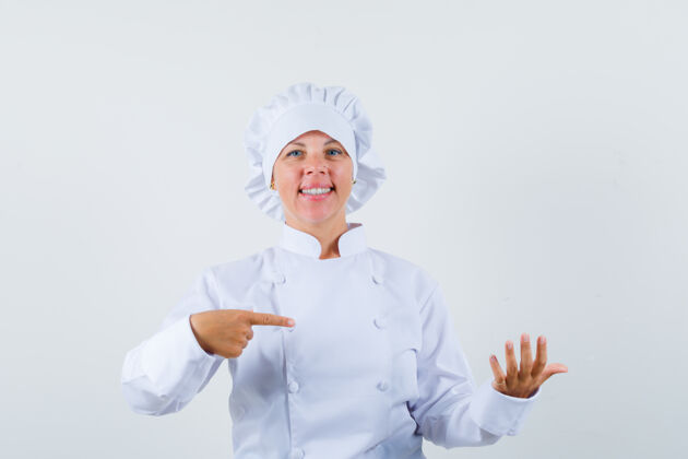指向一位女厨师指着一件假装穿着白色制服的东西 看上去很自信模特女士肖像