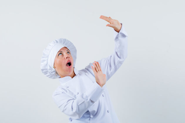 魅力女厨师举手为自己辩护 穿着白色制服 看起来很害怕肖像可爱时尚