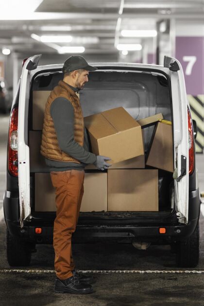 车侧视图：男人装包裹的车员工装货送货