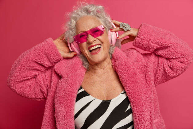 放松穿着粉色紧身衣和外套 满脸皱纹的时尚老奶奶的特写照片化妆老年快乐