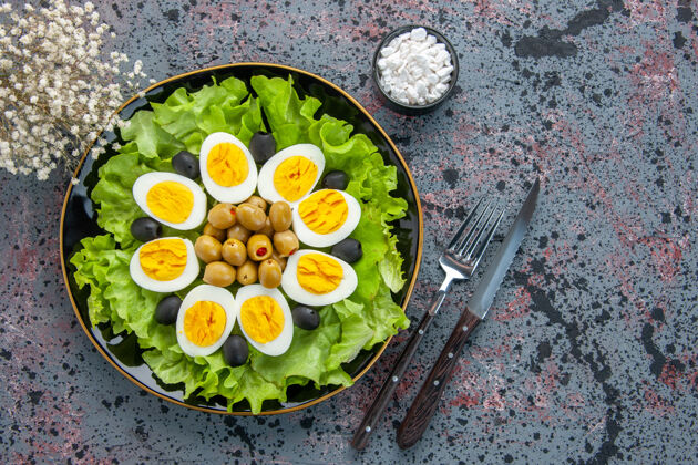 背景俯视图美味的鸡蛋沙拉由绿色沙拉和橄榄组成 背景色浅盘子营养品茶