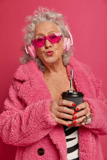 舒适穿着粉色紧身衣和外套 满脸皱纹的时尚老奶奶的特写照片音乐嘴唇茶