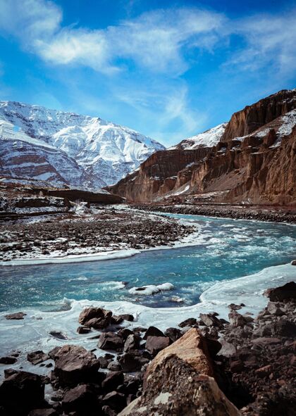 金丝雀垂直拍摄斯皮提山谷在冬季与冻结的河流和雪峰山脉粘土山峰颜色