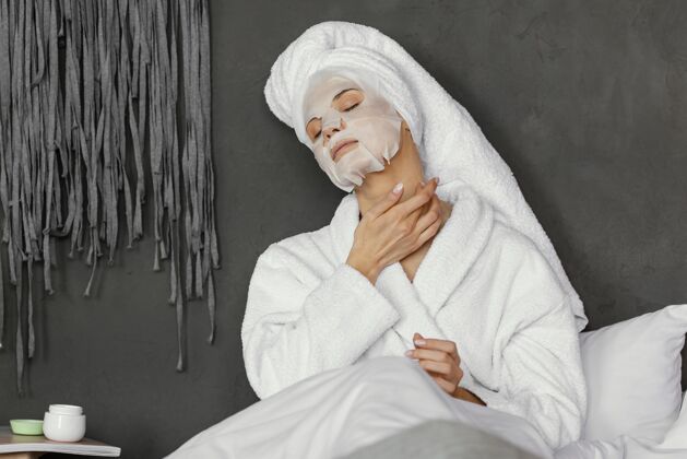 自理中等面罩的女人保健中景浴袍