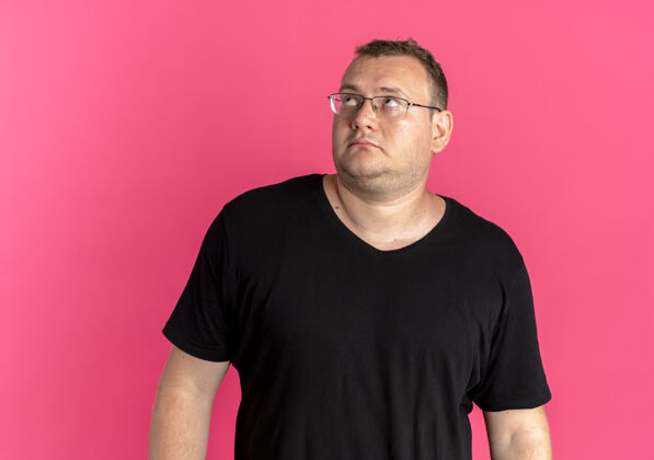 眼镜一个戴眼镜的胖男人穿着黑色t恤抬头看着粉色的脸黑色看超重
