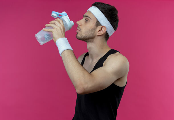 年轻年轻的运动型男子戴着头巾 在运动后喝着粉红色的水男人锻炼头带