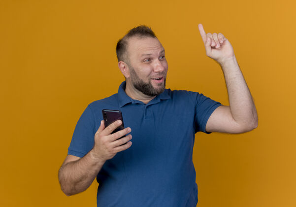 橙色印象深刻的成年斯拉夫男子看着一边举着手机举起手指电话手指印象