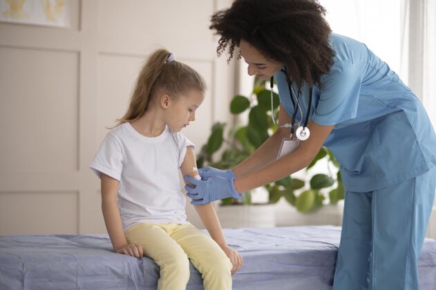 护理年轻的医生确保一个小女孩接种疫苗后是好的健康危险女孩