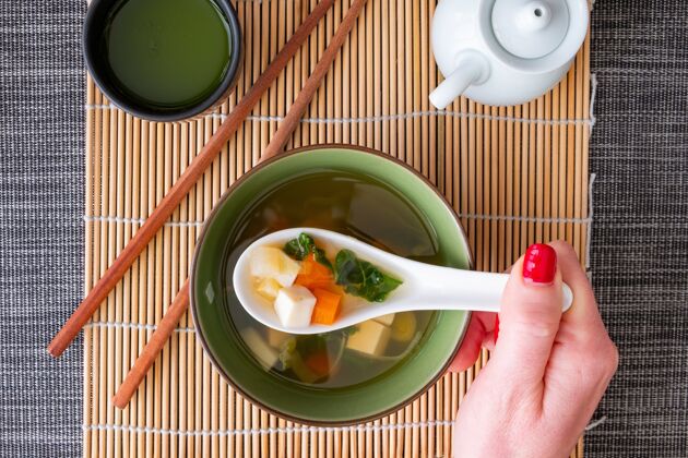 中国一个红指甲女孩吃味噌汤的俯视图蔬菜日本筷子