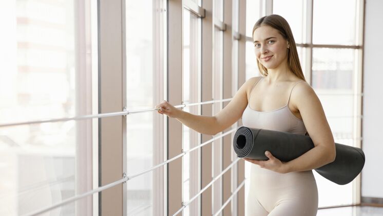 运动拿着瑜伽垫的中枪女人私人教练健康训练