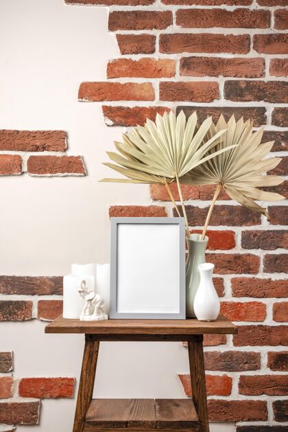 蜡烛空框放在花瓶旁边的架子上 上面放着干树叶干树叶相框空白相框