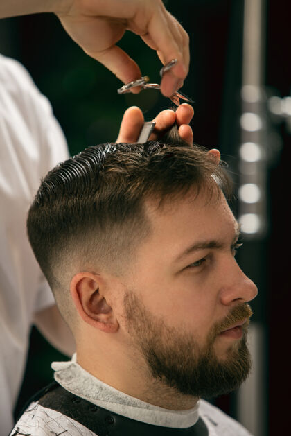 理发师理发师 发型师的客户在得到护理和发型的新面貌人男性设备