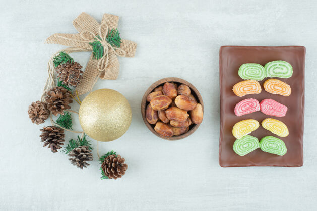 松果一盘果酱和圣诞金球在白色背景上高质量的照片蝴蝶结可食用果冻