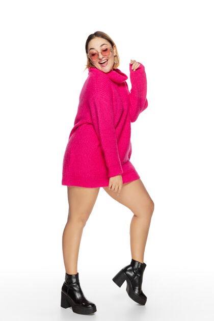 毛衣无忧无虑美丽的年轻女子亮粉色舒适毛衣 长袖隔离时髦身体衣服