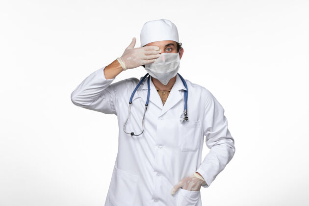 防护正面图身穿医疗服的男医生戴着无菌口罩 以防柯维德-白桌病毒疾病柯维德大流行面罩穿着视图