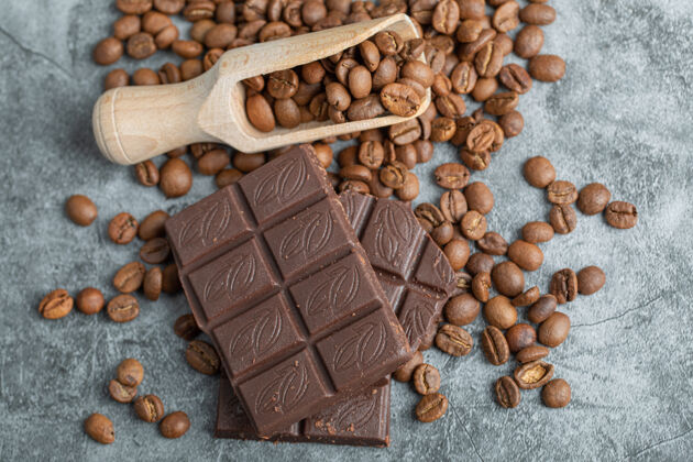 棒巧克力条和咖啡豆放在灰色的可食用的好吃的薯片