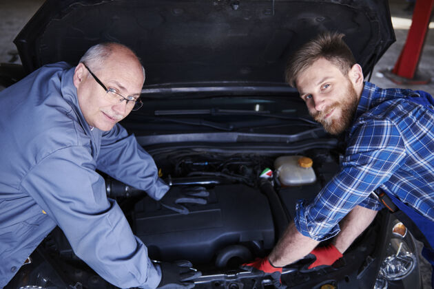 职业修理工在车间里修理汽车候选人微笑专业职业