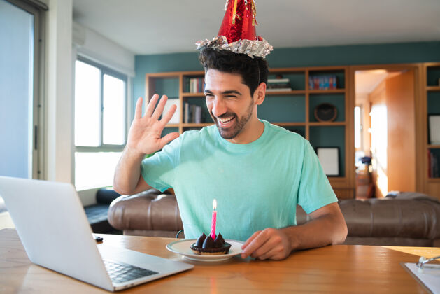 在线年轻人在家里用笔记本电脑和蛋糕通过视频电话庆祝生日的照片新的正常生活方式理念庆典连接视频通话