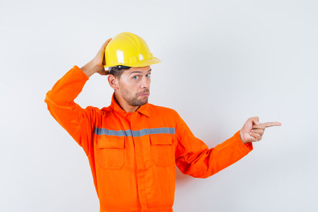 职业身着制服的建筑工人 头盔指向侧面 面带沉思 正前方工作养老金制服
