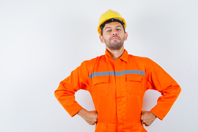工头穿着制服的建筑工人 手举头盔放在腰上 看上去很自信 前视图工作建筑师土建