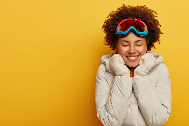 快乐快乐的非洲女人戴着滑雪面罩 温暖的针织手套和外套 喜欢户外活动快乐的女人穿着滑雪板夹克年轻保持