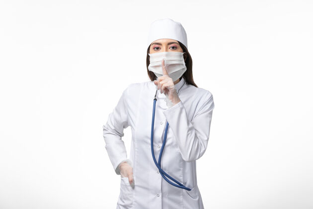 视图正面图：女医生穿着白色无菌医疗服 带着口罩 因为柯维德-白墙疾病-柯维德-大流行病毒疾病疾病到期冠状病毒