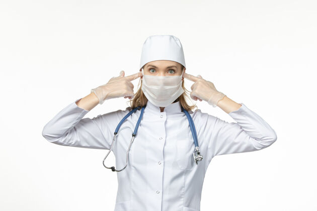 套装前视女医生穿着医疗服戴着口罩和手套因冠状病毒对光台冠状病毒-大流行性疾病病毒疾病人员专业大流行