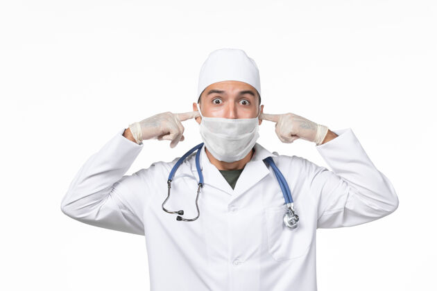 男性正面图男医生穿着医疗服 戴着口罩 由于柯维德-白墙疾病柯维德-大流行疾病视图制服正面