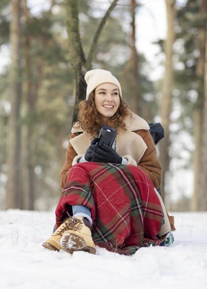女人坐在雪地上的全副武装的女人垂直毯子女人