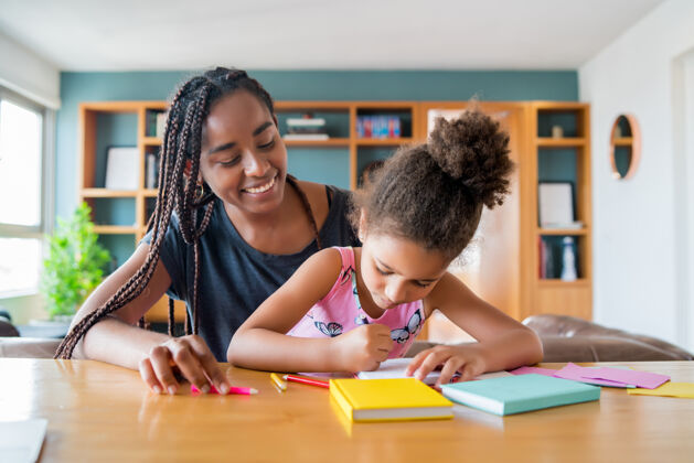 在一起母亲在家帮助和支持女儿在家上学新的正常生活方式理念家庭学校家庭作业在一起