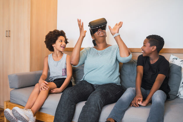 老人非裔美国人的祖母和孙子孙女在家里玩vr眼镜的画像家庭和技术概念非裔美国人女人科技