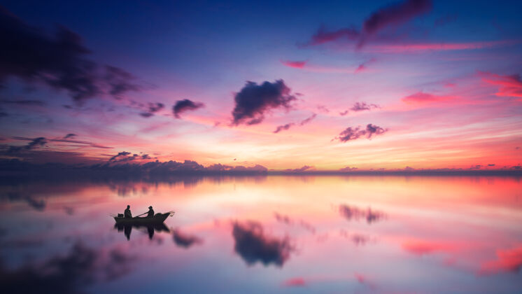 粉红色的天空白天两个人坐在船上的剪影日落风景户外
