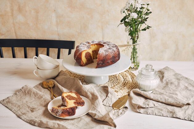 食物美丽的镜头美味的环蛋糕放在一个白色的盘子和一个白色的花靠近它派奶油早餐