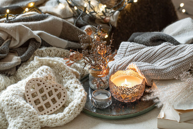 海格烛台上蜡烛的静物画 装饰细节和针织物情人节和家居装饰的概念礼物燃烧的蜡烛心