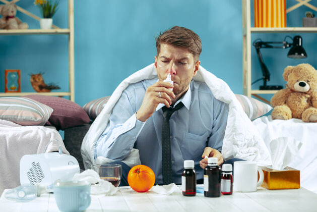 组织留着胡须的病人坐在家里的沙发上 铺上暖和的毯子 用鼻喷雾剂对疾病 流感 疼痛有概念在家放松鼻子病人流感