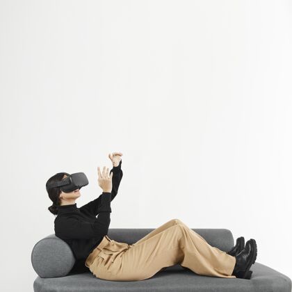 女人沙发上戴着虚拟现实耳机的女人科技小玩意女人