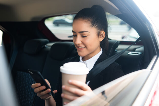 肖像商业女性在开车上班途中使用手机的照片商业概念无线人女商务人士