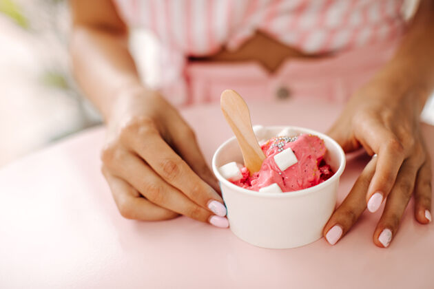 香草吃冰淇淋的女人的局部视图甜点的女人的选择性焦点模糊吃手