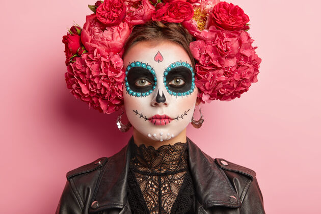 严肃冷静女性的肖像庆祝死亡日 有糖骷髅妆 黑眼圈靠近眼睛 画微笑 认为死亡是人类周期的自然部分 穿着传统的墨西哥服装艺术家夹克特写