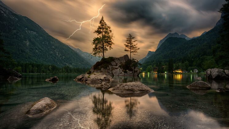 闪电在灰色的云层下 松树在山的附近形成岩石自然风景湖泊