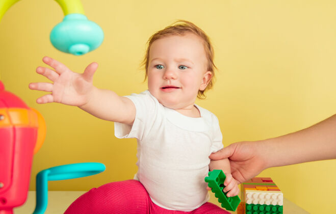 发展白人小女孩 黄色工作室背景上孤立的孩子可爱可爱的孩子的肖像 婴儿玩耍和欢笑肖像婴儿手势